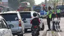 Aparat kepolisian Polres Cirebon Pantura mengatur lalu lintas kendaraan ke arah Tol Cipali, Indramayu, Jakarta dan ke arah Jawa Tengah di Pos Palimanan Cirebon, Jawa Barat, Jumat (30/6). (Liputan6.com/Helmi Afandi) 