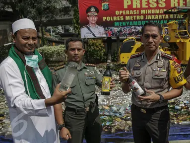 Petugas menunjukkan minuman keras sebelum dimusnahkan di Polres Jakarta Utara, Selasa (16/5). Sebanyak 16.421 botol minuman keras berbagai jenis dimusnahkan. (Liputan6.com/Faizal Fanani)
