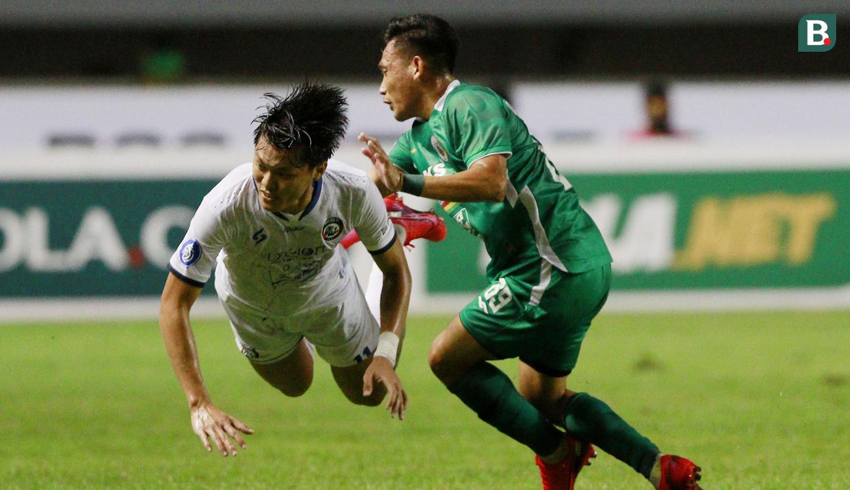 Pemain Arema FC, Feby Eka Putra (kiri) terjatuh saat berebut bola dengan pemain PSS Sleman, Derry Rachman dalam laga pekan ke-3 BRI Liga 1 2021/2022 di Stadion Pakansari, Bogor, Minggu (19/9/2021). Arema FC kalah 1-2. (Bola.com/M Iqbal Ichsan)