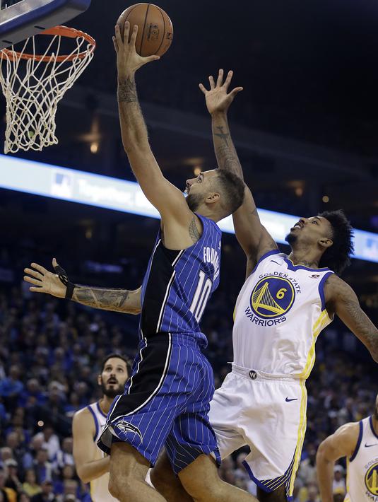Aksi pemain Orlando Magic, Evan Fournier melakukan tembakan lays up melewati adangan pemain Warriors, Nick Young (6) pada lanjutan NBA Basketball game di Oracle Arena, Oakland, (13/11/2017). Warriors menang 110-100. (AP/Ben Margot)