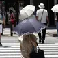 Orang-orang berjalan di bawah sinar matahari di Tokyo, Jepang, 12 Juli 2023. Cuaca panas pada hari Rabu telah ditetapkan dengan suhu naik lebih dari 36 derajat Celcius (97 derajat Fahrenheit) di Tokyo, menurut Badan Meteorologi Jepang. (AP Photo/Eugene Hoshiko)