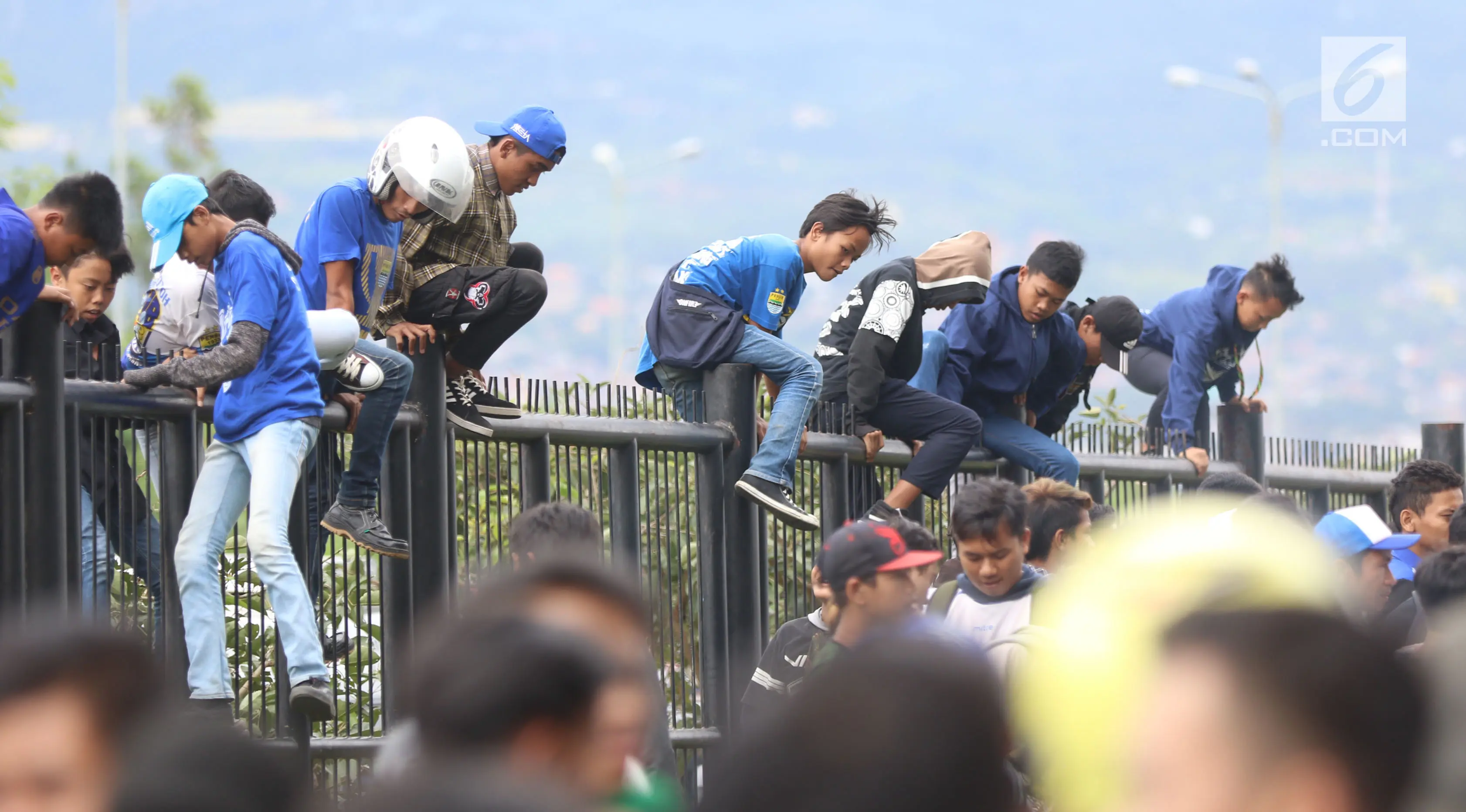 Suporter Persib memanjat pagar Stadion Gelora Bandung Lautan Api, Bandung, Selasa (16/1/2018). (Liputan6.com/Helmi Fithriansyah)