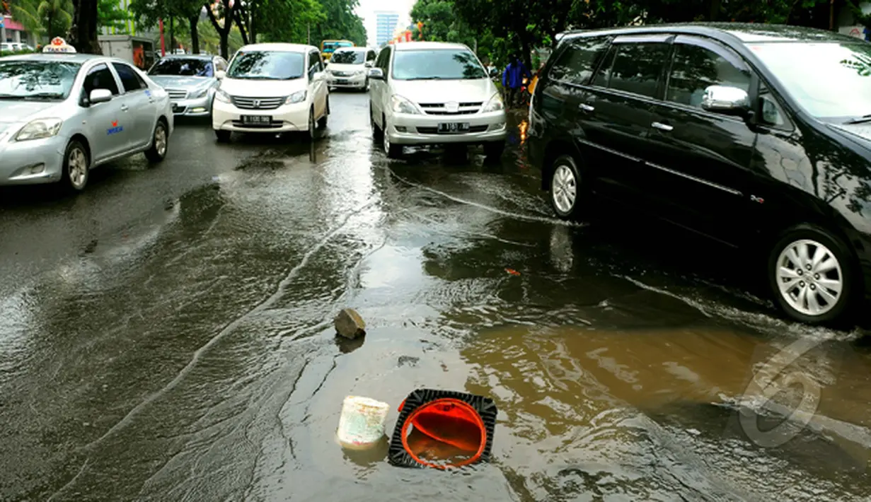 Pasca banjir, sejumlah lubang bermunculan di kawasan Kelapa Gading. Sebelumnya, kawasan ini terendam banjir setinggi 80 cm hingga memutuskan arus lalu lintas, Jakarta, Jumat (13/2/2015). (Liputan6.com/Faisal R Syam)