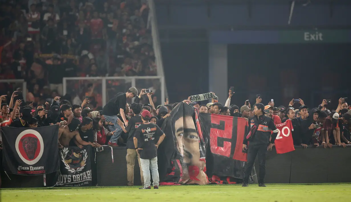 Suporter Persija memenuhi pinggir lapangan saat momen pensiun Bambang Pamungkas usai melawan Persebaya Surabaya pada laga Liga 1 di SUGBK, Jakarta, Selasa (17/12). Bepe mengakhiri kariernya pada musim ini. (Bola.com/Yoppy Renato)