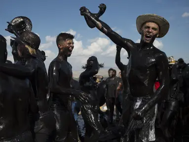 Para peserta dengan tubuh dilumuri minyak hitam mengikuti Festival Tradisionlal Cascamorras di Baza, Granada, Spanyol (6/9/2019). Festival ini diadakan setiap tanggal 6 September dan telah berlangsung selama 500 tahun terakhir. (AFP Photo/Jorge Guerrero)