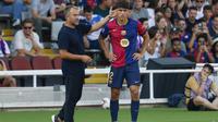 Pelatih Barcelona, Hansi Flick saat memberikan instruksi dari pinggir lapangan bersama pemainnya Pau Cubarsi. (AP Photo/Joan Monfort)