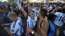 Para penggemar Argentina merayakan kemenangan atas Kroasia pada akhir pertandingan semifinal Piala Dunia  2022 Qatar setelah menontonnya di layar, di mana gambar langsung Lionel Messi ditampilkan, di lingkungan Palermo di Buenos Aires, Argentina, Rabu (14/12/2022). (AP Photo/Gustavo Garello)