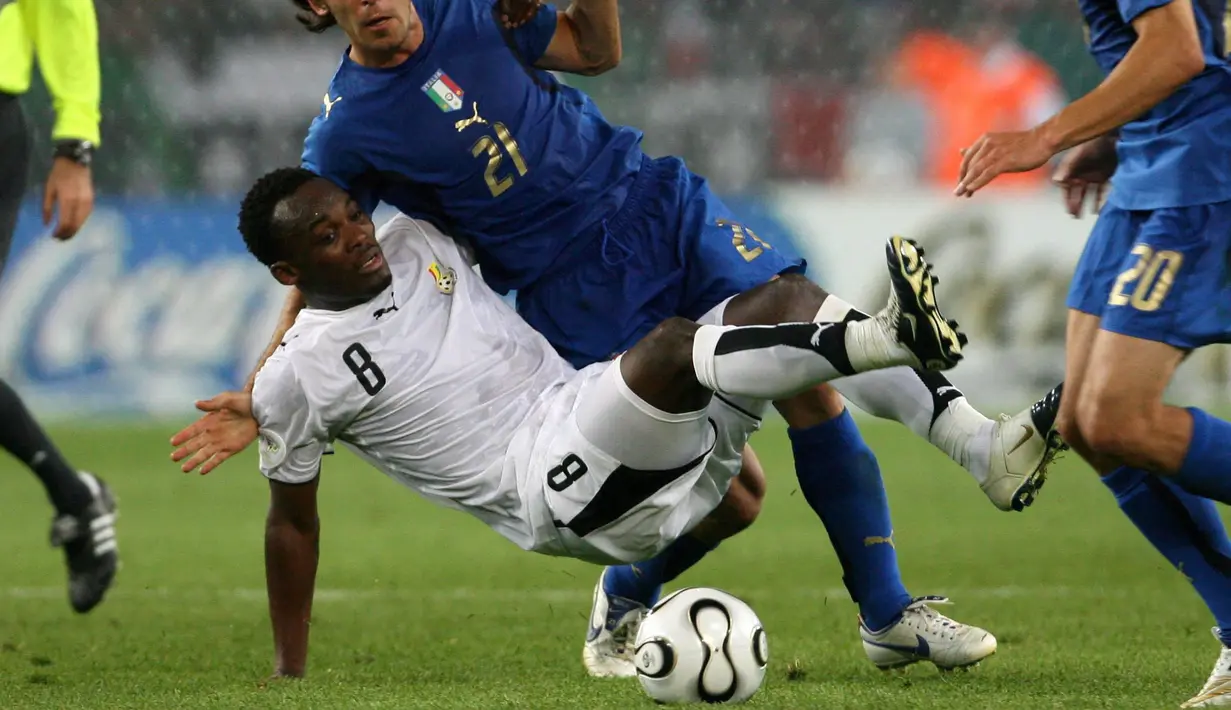 Gelandang Ghana, Michael Essien, merebut bola dari pemain Italia, Andrea Pirlo, pada laga Piala Dunia 2006. Memiliki kekuatan fisik di atas rata-rata membuat pria kelahiran Accra, Ghana ini  mendapatkan julukan, “The Bison”. (EPA/Kay Nietfeld)