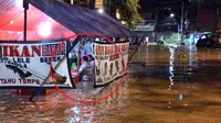 Gara-gara ada orang yang duduk di warung makan saat tengah bajir, hal ini mendapat beragam reaksi dari para warganet. Source: TMCPoldaMetro/Twitter