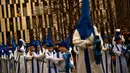Peniten bertopeng menyusuri jalan dalam prosesi Minggu Palma di Zaragoza, Spanyol, Minggu (25/3). Minggu Palma dirayakan menjelang Paskah. (Foto AP/Alvaro Barrientos)