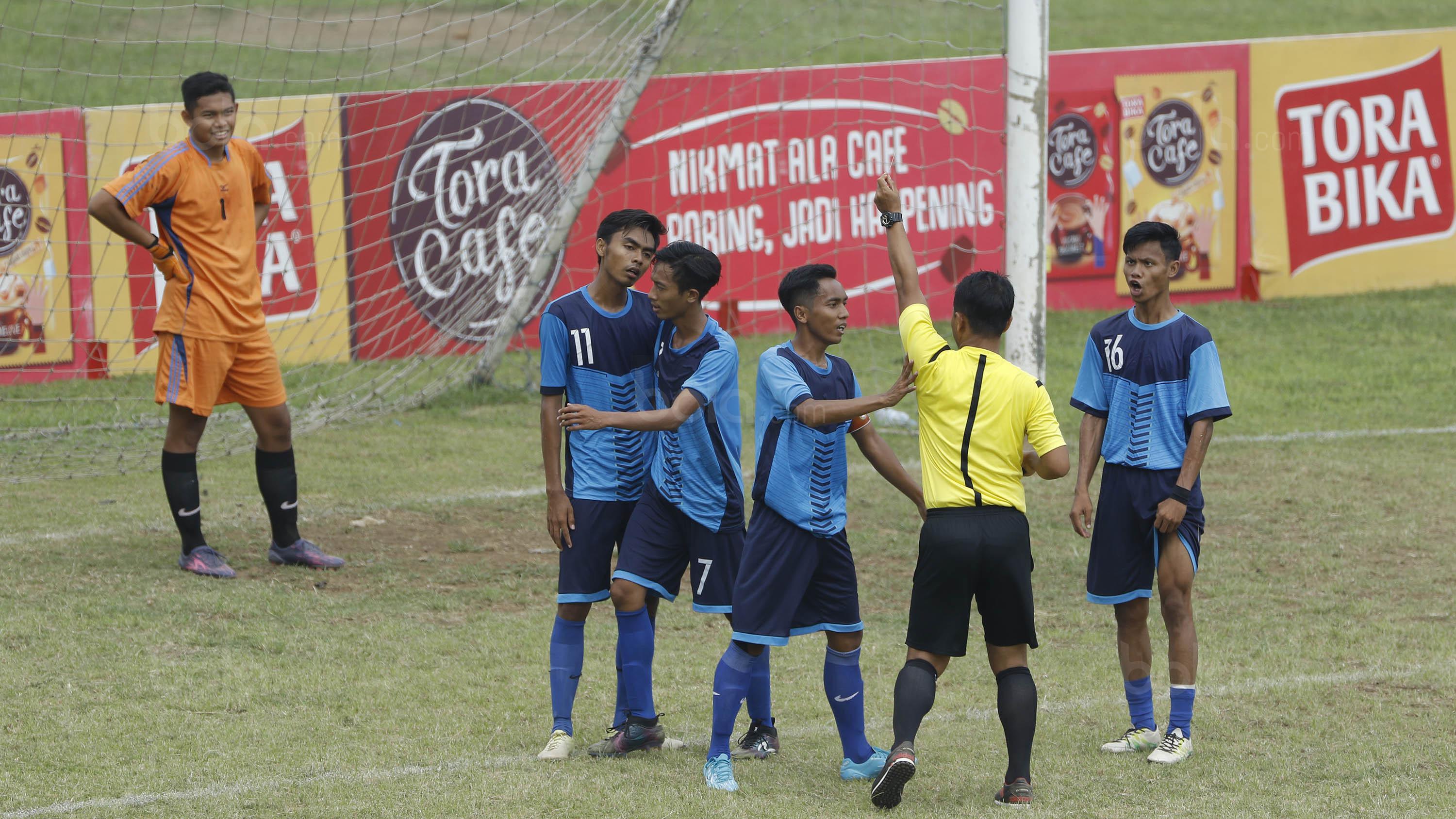 Wasit memberikan hukuman kartu kepada pemain Unitomo Surabaya saat melawan UMM Malang pada laga Torabika Campus Cup 2017 di Stadion Universitas Negeri Malang, Rabu, (01/11/2017). UMM menang adu penalti 4-3 atas Unitomo. (Bola.com/M Iqbal Ichsan)