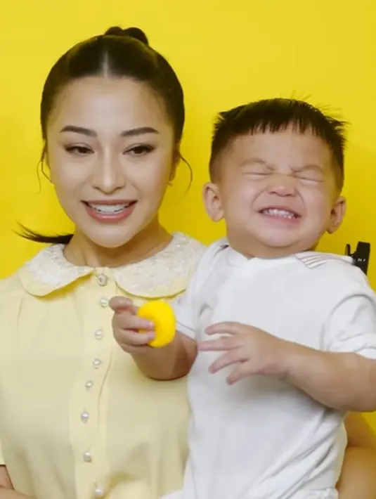 Gemasnya ekspresi Issa Ketika digendong oleh Nikita Willy. Nikita tampil cantik dengan dress kuning, sedangkan Issa mengenakan polo shirt berwarna putih. [Foto: Instagram/nikitawillyofficial94]