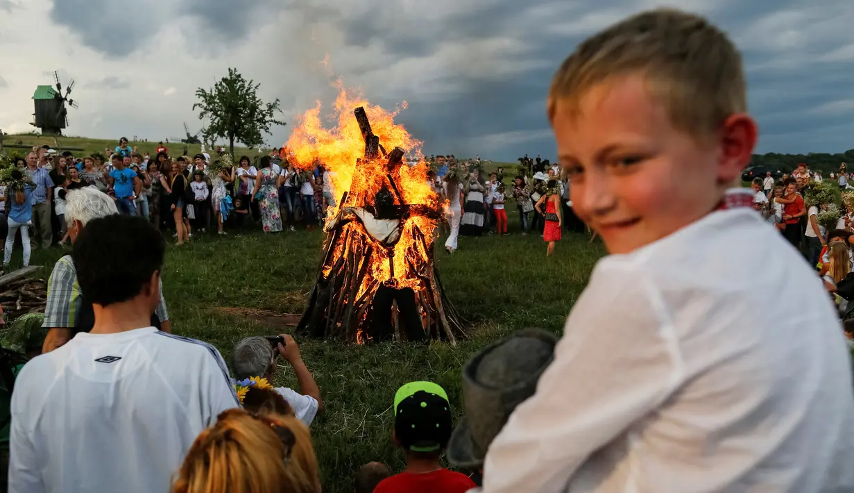 Warga berkumpul membentuk lingkaran sambil menari dan bernyanyi di sekitar api unggun saat perayaan Ivan Kupala di Kiev, Ukraina, Rabu (6/7). Mereka percaya akan kembali suci dengan mengikuti perayaan tersebut. (REUTERS/ Gleb Garanich)
