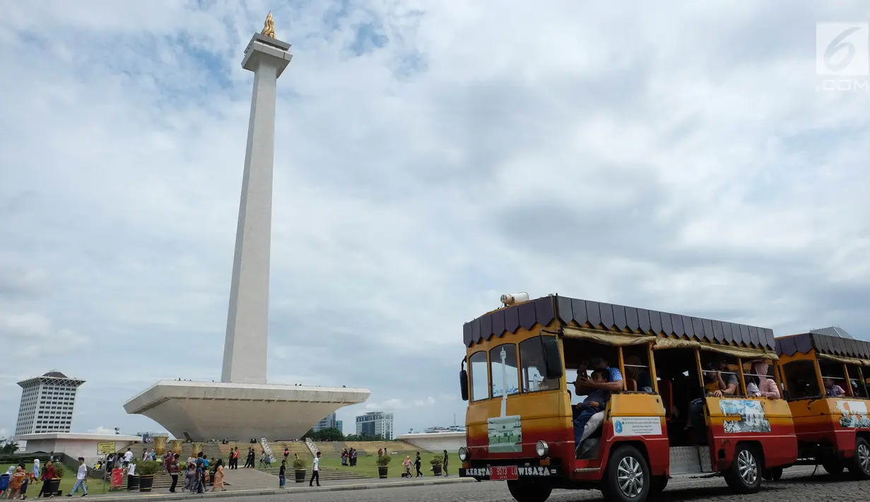 Sejumlah pengunjung menaki kereta wisata saat liburan di Monumen Nasional (monas), Jakarta, Selasa (25/12). Liburan Natal 2018, banyak warga datang bersama kerabat maupun keluarga memadati Monas. (Liputan6.com/Herman Zakharia)
