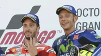 Valentino Rossi (kanan) mengaku tak kecewa kalah dari Andrea Dovizioso pada balapan MotoGP Inggris di Sirkuit Silverstone, Minggu (27/8/2017). (AP Photo/Rui Vieira)