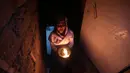 Seorang wanita Yazidi Irak membawa lilin di dalam kuil Lalish saat perayaan Tahun Baru Yazidi di lembah dekat Dohuk, Irak (17/4). Mereka menggelar ritual untuk merayakan Tahun Baru Yazidi. (AFP/Safin Hamed)