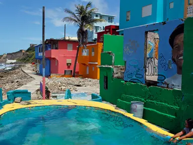Wisatawan menaiki tangga saat mengunjungi lokasi syuting video klip Despacito di La Perla, San Juan, Puerto Rico, 22 Juli 2017. Despacito mampu menaikkan pamor Puerto Rico karena disebut secara terang-terangan dalam lirik lagu ini. (Ricardo ARDUENGO/AFP)