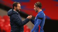 Gelandang Inggris, Jack Grealish (kanan), disalami pelatih Gareth Southgate usai digantikan dalam laga uji coba internasional di Stadion Wembley, London, Jumat (13/11/2020) dini hari WIB. Inggris menang 3-0 atas Republik Irlandia. (AFP/Carl Recine/Pool)