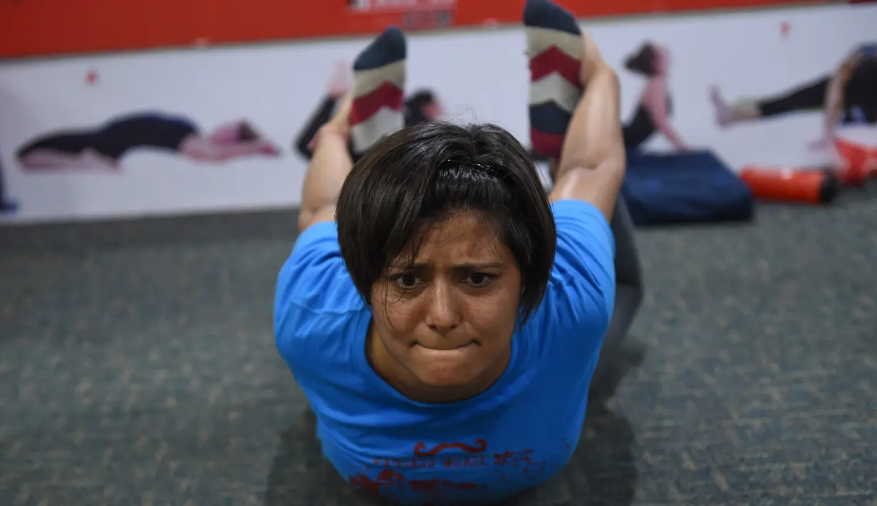 Seorang wanita India saat berlatih di gym Ahmedabad Fitness Academy (AFA) di Ahmedabad (10/5/2019). Selama bulan suci Ramadhan, tempat gym ini tetap buka hingga larut malam untuk membiarkan anggota Muslim berolahraga setelah salat. (AFP Photo/Sam Panthaky)