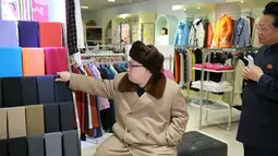 Kim Jong Un melihat bahan pakaian saat memberikan arahan di tengah kunjungannya di sebuah pusat perbelanjaan yang baru dibangun di kompleks Mirae Shop di Korea Utara (28/3). (REUTERS/KCNA)