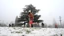 Orang-orang menikmati hujan salju pertama musim ini di Katoomba di pegunungan Blue Mountains, Kamis (10/6/2021). Katoomba berada di New South Wales, selatan Australia atau 102 kilometer sebelah barat Sydney.  (AFP/Saeed KHAN)