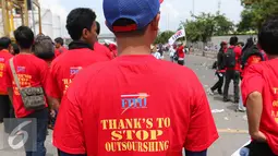 Federasi Pekerja Pelabuhan Indonesia (FPPI) melakukan aksi di Pelabuhan Tanjung Priok, Jakarta, Minggu (1/5). Buruh mengenakan kaos bertuliskan Stop Outsourshing (Liputan6.com/Angga Yuniar)