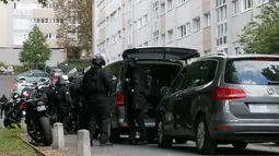 RAID (satuan polisi elit) mengepung sebuah bangunan tempat tinggal pelaku penembakan di supermarket Kota Port-Marly, dekat Paris, Senin (26/9). Kakek itu menembak kasir berusia 57 tahun dan pria berusia 73 tahun sebelum melarikan diri. (Thomas Samson/AFP)