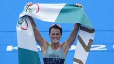 Atlet Bermuda, Flora Duffy berbelebrasi setelah melewati garis finis untuk meraih medali emas dalam triathlon nomor individu putri Olimpiade Tokyo 2020 di Odaiba Marine Park, Selasa (27/7/2021). Flora Duffy menjadi penyumbang medali emas untuk negara berpenduduk 60 ribu orang itu. (AP/David Goldman)