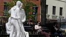 Dua perempuan duduk di dekat patung yang disebut 'Gay Liberation' di Christopher Park, Greenwich Village New York City, AS, (9/5). Patung ini dibuat untuk memperingati peristiwa pembebasan gay dan lesbian di Amerika Serikat. (REUTERS / Brendan McDermid)