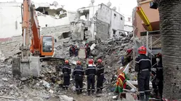 Petugas menggunakan alat berat untuk mencari korban yang terjebak di puing-puing gedung yang runtuh, Maroko, Minggu (13/7/14). (REUTERS/Macao)