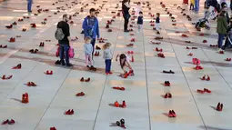 Orang-orang berjalan melewati instalasi ratusan sepatu merah untuk memprotes kekerasan terhadap perempuan di kota pesisir Tel Aviv, Selasa (4/12). Sepanjang tahun ini, 24 perempuan Israel tewas akibat tindakan kekerasan dalam rumah tangga. (JACK GUEZ/AFP)