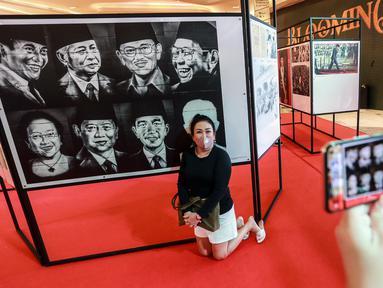Pengunjung berfoto saat Pameran Foto Potret 7 Presiden RI dengan tema "7 Citizen No.1" di Mall Neo Soho, Jakarta, Selasa (22/11/2022). Foto-foto yang dipamerkan merupakan foto bersejarah bagi bangsa Indonesia. (Liputan6.com/Johan Tallo)