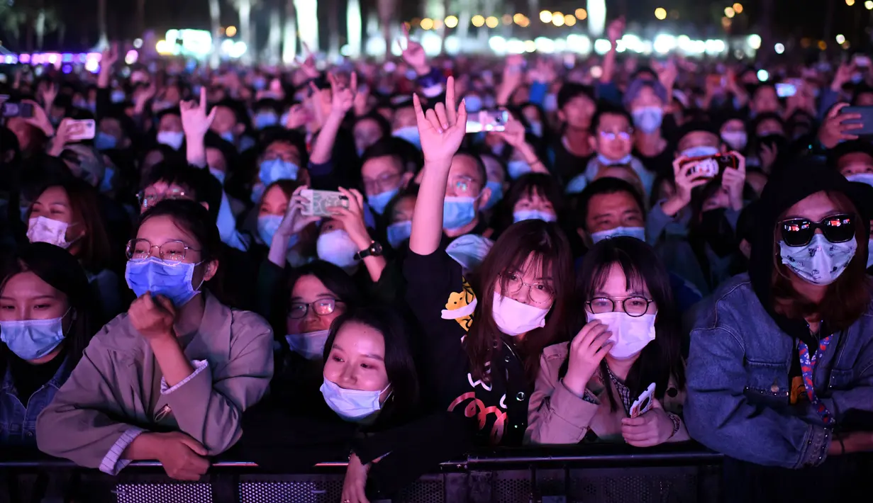 Orang-orang yang memakai masker menyaksikan penampilan sebuah band pada Festival Musik Rye yang digelar selama dua hari di Beijing pada 18 Oktober 2020. (Photo by Noel Celis / AFP)