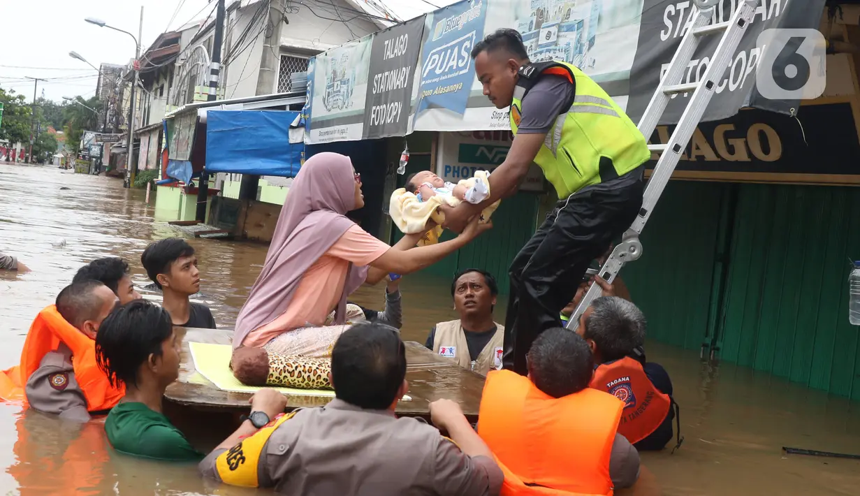 Petugas membantu mengevakuasi bayi yang terjebak banjir di perumahan Ciledug Indah, Tangerang, Rabu (1/1/2020). Banjir setinggi dada orang dewasa terjadi akibat meluapnya kali angke. (Liputan6.com/Angga Yuniar)