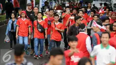  Pendukung Timnas Indonesia berjalan menuju Stadion Pakansari, Bogor (3/12). Timnas Indonesia akan melakoni laga semifinal pertama Piala AFF 2016 melawan Vietnam di Stadion Pakansari Kab Bogor. (Liputan6.com/Helmi Fithriansyah)