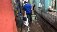 Warga membawa air untuk membersihkan lumpur sisa banjir yang menggenangi kawasan Rawajati, Jakarta Selatan, Selasa (6/2). Banjir yang mulai surut dimanfaatkan warga untuk membersihkan lumpur. (Liputan6.com/Immanuel Antonius)