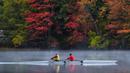 Sepasang pendayung meluncur di Sungai Androscoggin di Brunswick, Maine, tempat dedaunan berubah menjadi warna musim gugur, pada 10 Oktober 2021. Salah satu yang paling khas dari musim gugur adalah pohon-pohon yang berubah warna sebelum gugur. (AP Photo/Robert F. Bukaty)