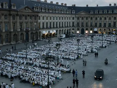Ratusan orang turut ambil bagian dalam 'Diner en blanc' atau 'Makan Malam Putih' digelar di Place Vendome, Paris, Rabu (8/6). Dalam tradisi yang sudah digelar selama 25 tahun itu, peserta harus mengenakan aksesoris serba putih. (PHILIPPE LOPE/AFP)