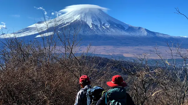 Para pendaki berjalan di Gunung Ishiwari dengan latar belakang Gunung Fuji di dekat Oshino, prefektur Yamanashi. Behrouz MEHRI / AFP