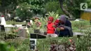 Peziarah membaca doa di salah satu makam di Tempat Pemakaman Umum Karet Bivak, Jakarta, Sabtu (18/4/2020). Selama masa PSBB, peziarah yang memasuki kawasan TPU dibatasi dan diwajibkan menggunakan masker sebagai langkah pencegahan penyebaran virus Covid-19. (Liputan6.com/Helmi Fithriansyah)