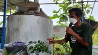 Sutrimo, Ketua Kelompok Setaria di Sangasanga, Kutai Kartanegara, Kalimantan Timur, berfoto bersama inovasi DAMKAR, Alat Destilasi Asap Sekam Bakar.