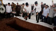 Presiden ke-6 Susilo Bambang Yudhoyono (SBY) disaksikan Agus Harimurti menaburkan tanah yang pertama kali ke makam sang ibu, Siti Habibah, di TPU Tanah Kusir Jakarta, Sabtu (31/8/2019). Ibunda SBY, almarhumah Siti Habibah meninggal pada Jumat (30/8) pukul 19.21 WIB. (merdeka.com/magang/Ahmad Sujana)