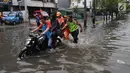 Petugas PPSU dan kepolisian mendorong motor yang mogok melintasi banjir di kawasan Duta, Jelambar, Jakarta Barat, Selasa (5/3). Hujan yang mengguyur Jakarta dan sekitarnya sejak dini hari membuat beberapa kawasan terendam banjir. (merdeka.com/Arie Basuki)