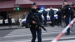 Seorang polisi wanita berjaga-jaga di sekitar Museum Louvre, Perancis, Jumat (3/2). Daerah di sekitar Museum Louvre telah diamankan dan tertutup untuk sementara. (AP Photo/Thibault Camus)