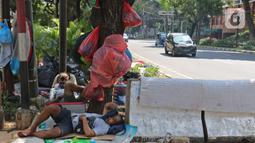 Pencari suaka beristirahat di trotoar kantor UNHCR, Jalan Kebon Sirih, Jakarta, Sabtu (1/5/2021). Para pencari suaka itu menuntut Komisi Tinggi PBB untuk Pengungsi (UNHCR) meminta kejelasan atas status dan memperhatikan nasib mereka selama hidup di Indonesia. (Liputan6.com/Herman Zakharia)