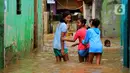 Anak-anak bermain banjir yang melanda kawasan Bidara Cina, Kecamatan Jatinegara, Jakarta Timur, Selasa (25/2/2020). Baru satu hari air surut, kawasan Bidara Cina yang bersebelahan dengan Kali Ciliwung kembali mengalami banjir. (merdeka.com/magang/ Muhammad Fayyadh)