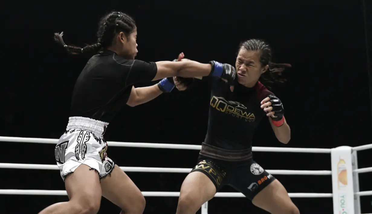 Petarung Indonesia, Priscilla Lumban Gaol, beradu pukulan dengan petarung Kamboja, Nou Srey Pov, pada laga ONE Championship di Istora Senayan, Jakarta, Jumat (3/5). Priscilla menang mutlak atas lawannya. (Bola.com/Yoppy Renato)