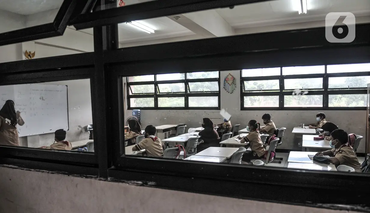 Suasana saat siswa mengikuti pembelajaran tatap muka di salah satu ruang kelas SDN Pulogadung 07, Jakarta, Rabu (7/4/2021). Siswa wajib mengenakan masker dan menjalani protokol kesehatan sebelum memasuki kelas seperti pemeriksaan suhu tubuh dan mencuci tangan. (merdeka.com/Iqbal S. Nugroho)