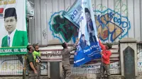 Anggota Satpol PP Kota Depok melakukan penertiban spanduk parpol di wilayah Kecamatan Bojongsari, Kota Depok. (Liputan6.com/Dicky Agung Prihanto)