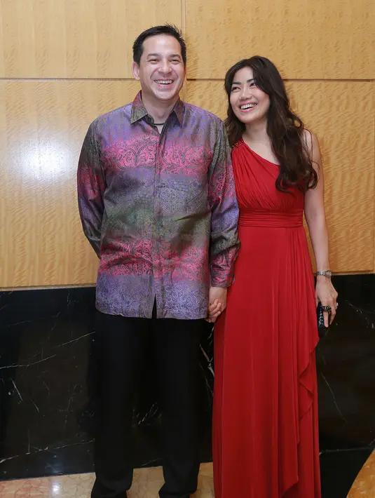 Ari Wibowo dan sang istri, Inge Anugrah, tampil serasi dengan memakai kemeja formal didampingi istri yang memakai gaun merah cantik. (Galih W. Satria/Bintang.com)